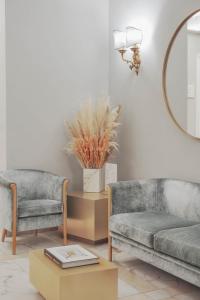 - un salon avec deux chaises, un canapé et un miroir dans l'établissement Hotel City Palazzo Dei Cardinali, à Rome