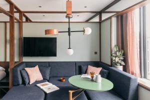 un soggiorno con un divano blu e un tavolo di Locke at Postbyen a Copenaghen