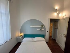 a bedroom with a white bed and a blue wall at il Casale di Adriana in Grugliasco