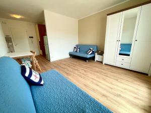 a living room with a blue couch and a chair at Bright studio only 320mt from the sea in Porto Santa Margherita di Caorle
