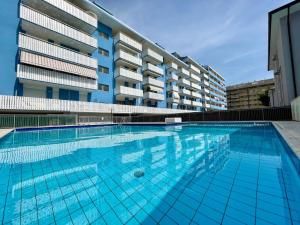 a large swimming pool in front of a building at Bright studio only 320mt from the sea in Porto Santa Margherita di Caorle