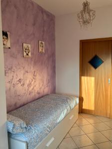a bedroom with a bed with a pink wall at Rosemary s House Napoli Vomero Private Parking in Naples