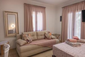 a living room with a couch and a mirror at Myrina Retreat - Aegean in Mirina