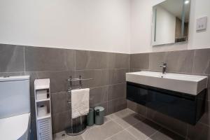 Un baño con un lavabo blanco y un espejo. en Rookery Park Barn, en Carlton Colville