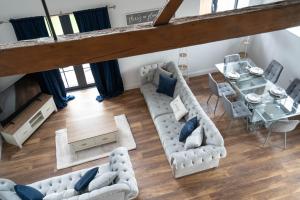 una vista aérea de una sala de estar con sofás y una mesa en Rookery Park Barn, en Carlton Colville