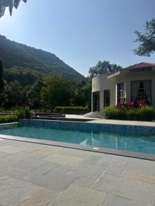 a swimming pool in front of a house at Surya Bagh - A Luxury Hideaway - 5 minutes to Ajabgarh, 10 minutes to Bhangarh & 20 minutes to Tehla, Sariska in Ajabgarh
