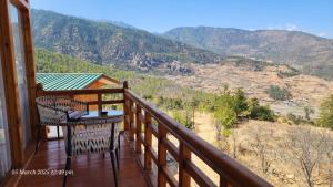 Un balcón con dos sillas y una mesa con vista. en Nangter Retreat, en Paro