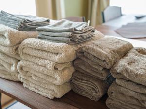 a pile of towels are stacked on a table at Newly Opened Kinugawa Onsen surrounded by nature, entire house available for rent, accommodates up to 7 people, 8-minute walk from the nearest station in Nikko +35 photos