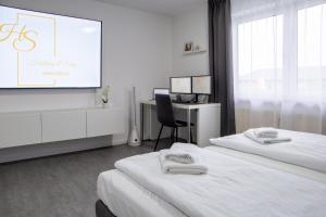 a hotel room with two beds and a projector screen at Holiday&Stay, Apartment Relax, Küche, 85Zoll TV, WLAN in Weingarten +10 photos