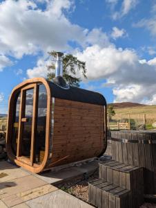 a wooden hobbit house with a chimney on top at Tomnauld Farm Wellness Cottage in Pitlochry