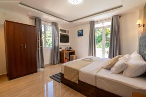 a bedroom with a large bed and a large window at Twin Villa Red - Cozy Colonial Villa with Mountain View in Nuwara Eliya