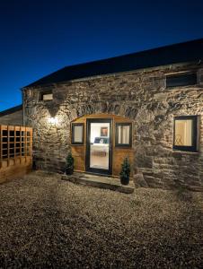 a stone house with a large glass door at Tomnauld Farm Wellness Cottage in Pitlochry +19 photos