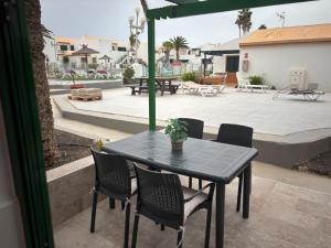 a black table and chairs on a patio at Puerta del Sol Caleta Fuste (Fuerteventura) in Caleta De Fuste