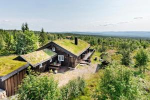 ein Bild eines Hauses mit einem Grasdach in der Unterkunft Family-Friendly Log Cabin With Panoramic View in Østby