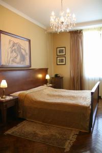 a bedroom with a large bed and a chandelier at Dom Retro Pivnica in Jastrzębie Zdrój