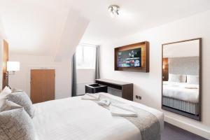 a hotel room with a bed and a mirror at Rivers hotel in Newcastle upon Tyne
