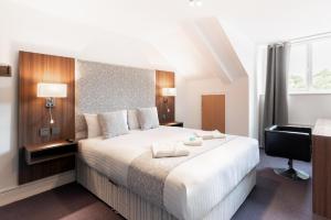 a bedroom with a large white bed and a desk at Rivers hotel in Newcastle upon Tyne