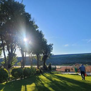 a man walking through a park with the sun shining at Dree-Gevels-Huus in Harlesiel