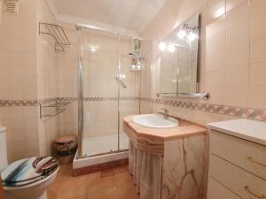 a bathroom with a shower and a sink and a toilet at Casa T2 in Monte Gordo