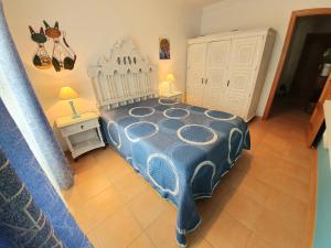 a bedroom with a blue and white bed and a table at Casa T2 in Monte Gordo