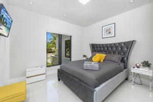 a bedroom with a gray bed with a yellow pillow at Villa Sienna Coastal Warmth in Hollywood +42 photos