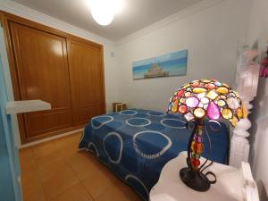 a bedroom with a bed with a stained glass table at Casa T2 in Monte Gordo +4 photos