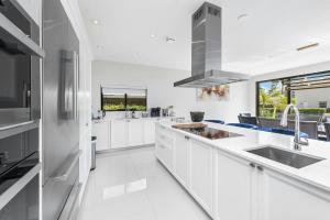 a white kitchen with white cabinets and a sink at Villa Sienna Coastal Warmth in Hollywood