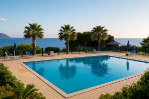 a pool with palm trees and the ocean in the background at Vulcanello Sea View Apartment in La Fabbrica
