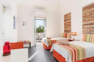 a hotel room with two beds and a table at OurMadeira - Grayci's House, contemporary in Arco da Calheta +17 photos