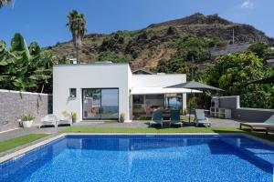 a villa with a swimming pool and a house at OurMadeira - Grayci's House, contemporary in Arco da Calheta