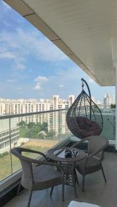 un balcon avec une table et deux chaises et un panier suspendu dans l'établissement House of Magical Escapes Luxury Stays, à Dhankot 15 autres photos
