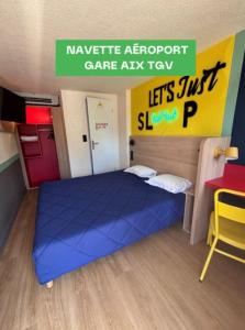 a bedroom with a blue bed in a lego room at Première Classe Aéroport Marseille in Vitrolles