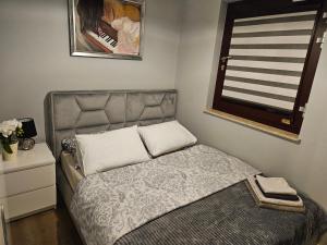 una piccola camera da letto con un letto e una finestra di Apartament Chmielna - Waterlane Island a Danzica Altre 23 foto