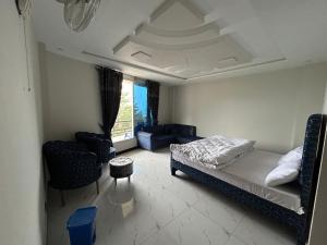 a bedroom with a bed and chairs in a room at askari lodges in Murree