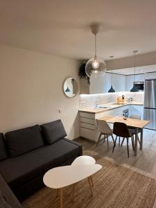 a living room with a couch and a table and a kitchen at Apartamentos La Pinilla in La Pinilla