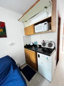 a small kitchen with a sink and a microwave at Flat com Hidromassagem Privativa - Porto de Galinhas - Sol e Mar Residence in Porto De Galinhas