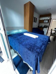 a bedroom with a bed with a blue blanket at Flat com Hidromassagem Privativa - Porto de Galinhas - Sol e Mar Residence in Porto De Galinhas +13 photos