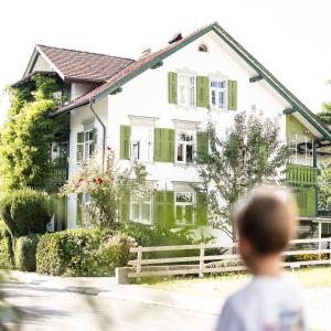 a boy walks past a house at Casa Verde Dornbirn in Dornbirn