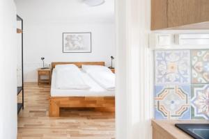 a bedroom with a bed and a kitchen with a sink at Casa Verde Dornbirn in Dornbirn