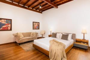 a bedroom with a large bed and a couch at La Muraille, Galle Fort in Galle +42 photos
