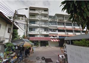 a large apartment building with a market in front of it at BaanSathorn21 in Bangkok