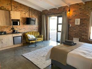 a hotel room with a bed and a kitchen and a kitchen at MK & R Guesthouse in Alberton