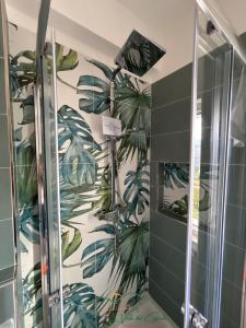 a shower stall with a mural of plants on the wall at La valle del ciglioto in Licusati