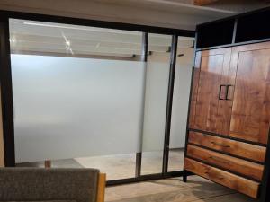 a bedroom with a sliding glass door and a dresser at Little Orvyll's in Marloth Park