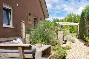 a garden with a wooden bench next to a house at Pension Trent in Trent