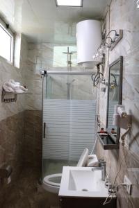 une salle de bain avec un lavabo, une douche et des toilettes dans l'établissement Tilman Hotel, à Addis-Abeba 10 autres photos