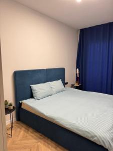 a bed with a blue headboard in a room at Dreams home in Uzhhorod