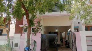 a house with a tree in front of it at Aala Stays in Tirunelveli