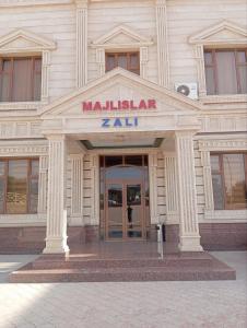 a building with the entrance to a museum with a sign at Hayot Hotel Skazka in Qarshi
