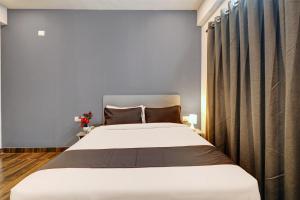 un dormitorio con una cama grande en una habitación en Super Townhouse Ecity Inn, en Bangalore